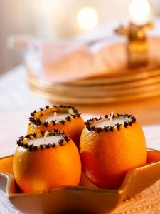 Hollowed out oranges, opening ringed with cloves, tea lights.